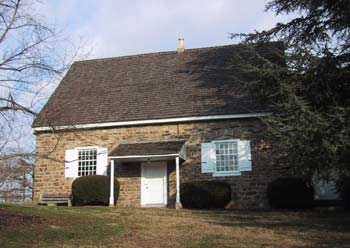 front door facade of the meeting house; plain stone one-story building