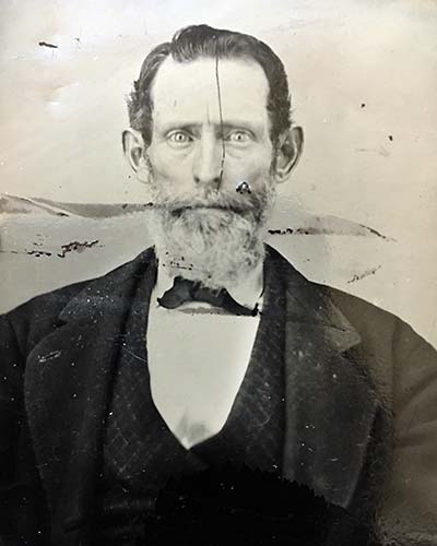 older man, gaunt, wild-eyed, photo scratched across face, other damaged spots