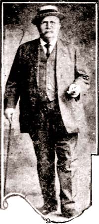 full-height portrait, old man in suit, vest, straw hat, leans on a cane