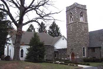 church im=n two sections, gray stone steeple on right, white church on left