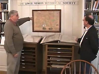 Jerry points to a historical map on the wall