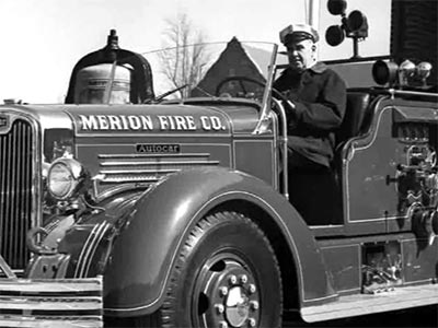fireman driving a vintage firetruck