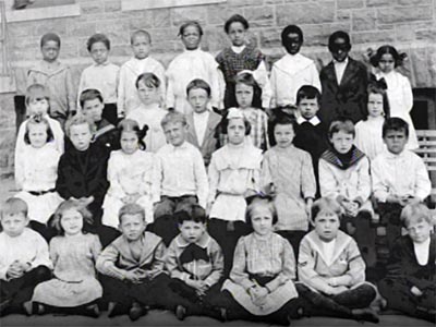 old elementary school class photo, white kids in front rows, blacks separated in the back row