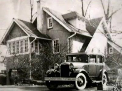 early car in front of a house
