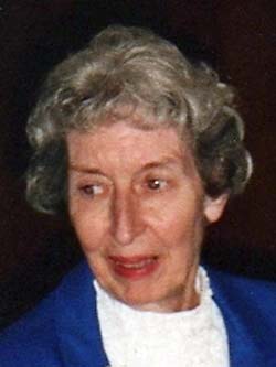 gray-haired lady in a blue jacket and white shirt, head and shoulders photo